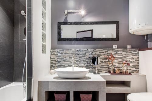 une salle de bain avec un lavabo et un miroir dans l'établissement L'Authentik, charme et confort en vieille ville, à Annecy