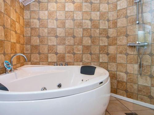 a bath tub in a bathroom with a tiled wall at 8 person holiday home in Hovborg in Hovborg