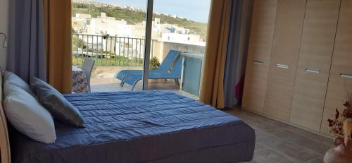 a bedroom with a bed and a view of a balcony at Harruba Flt 3 Triq il Gudja in Mġarr
