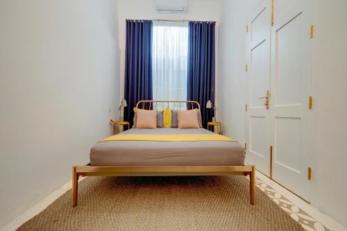 a bedroom with a bed and a window with blue curtains at Traditional Maltese Townhouse wt Terrace and Pool in Senglea