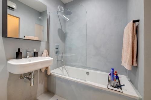 a bathroom with a sink and a shower and a tub at Traditional Maltese Townhouse wt Terrace and Pool in Senglea