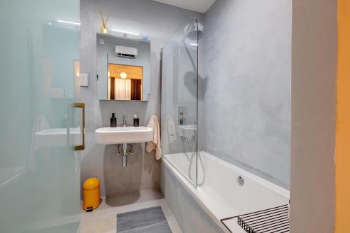 a bathroom with a sink and a shower and a tub at Traditional Maltese Townhouse wt Terrace and Pool in Senglea