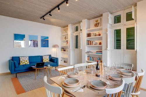 a dining room with a table and a blue couch at Traditional Maltese Townhouse wt Terrace and Pool in Senglea