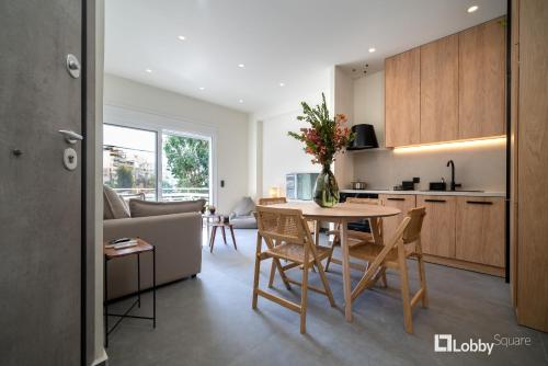 a kitchen and living room with a table and chairs at La Mer Apartment by LobbySquare in Piraeus