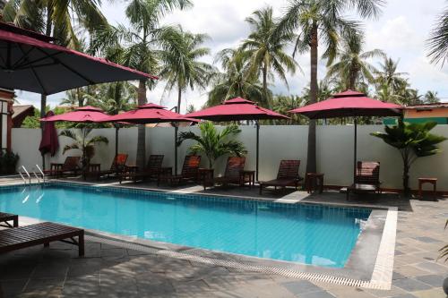 basen z leżakami i parasolami w obiekcie Villa Mahasok hotel w mieście Luang Prabang