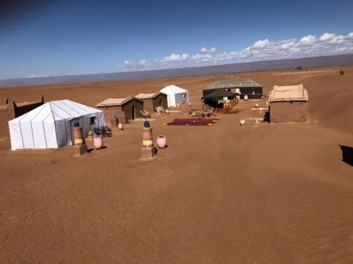 an aerial view of a desert with tents in a field at desert Feeling in Mhamid