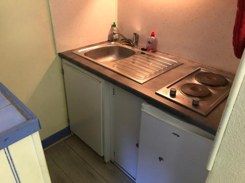 eine kleine Küche mit einer Spüle und einer Theke in der Unterkunft Baréges : Appartement Résidence de l’Ayré in Barèges