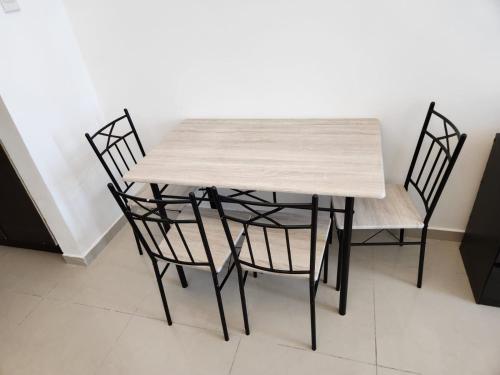 a wooden table with four black chairs and a table at Furnished Studio apartment near Business Bay Metro Station in Dubai
