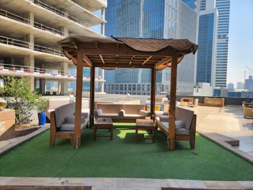 a gazebo with chairs and tables on a rooftop at Furnished Studio apartment near Business Bay Metro Station in Dubai
