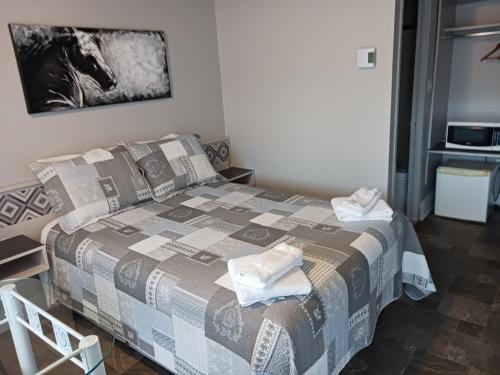 a bedroom with a bed with towels on it at Motel du rosier in Baie-Comeau