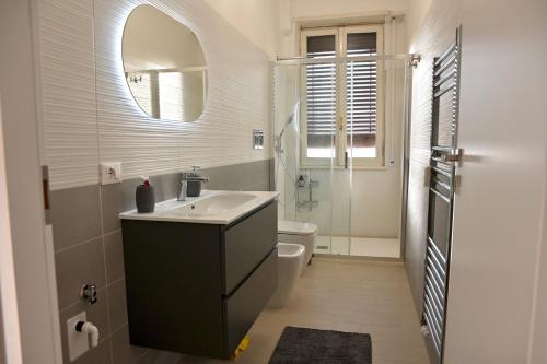 ein Badezimmer mit einem Waschbecken, einem WC und einem Spiegel in der Unterkunft Emerenziana Lovely Apartment in Rom