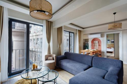 a living room with a blue couch and a glass table at Galata Abraham by NewInn in Istanbul