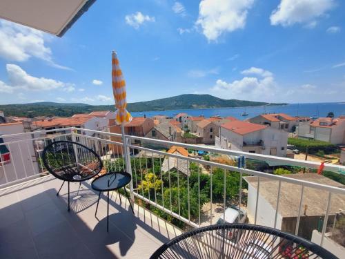 - un balcon avec deux chaises et une vue sur l'eau dans l'établissement Vinko rooms, à Primošten