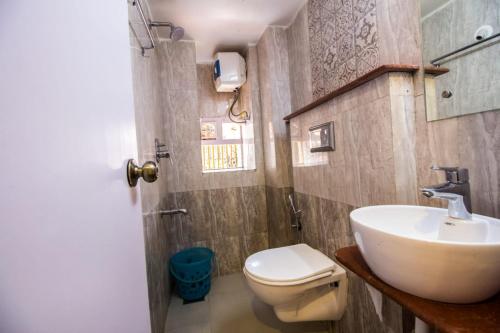 a bathroom with a white toilet and a sink at Marquito's Guest House in Panaji