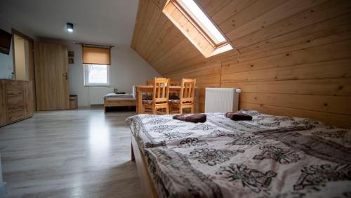 1 dormitorio con 1 cama grande en una habitación de madera en U Jędrusia, en Zubrzyca Górna