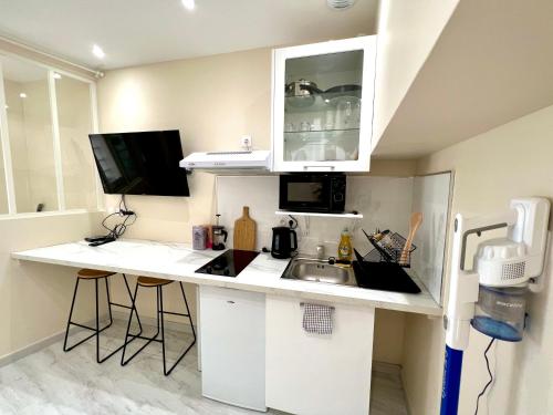 a small kitchen with a sink and a counter at Toulouse : Studio équipé au cœur de St-Cyprien in Toulouse