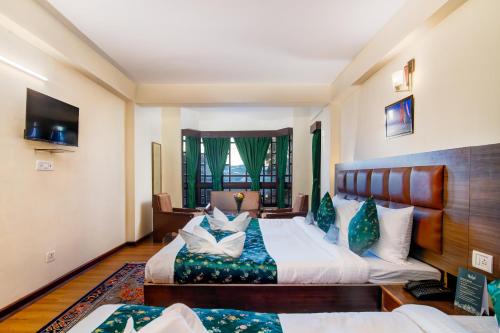 a hotel room with two beds and a couch at Muscatel BhumSang - 200 Mts from Mall Road in Darjeeling