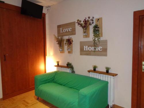 un sofá verde en una sala de estar con algunas plantas en Loft House Budapest, en Budapest