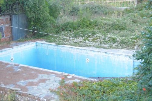 una pequeña piscina azul en un patio en Chalikias Rooms, en Asprogerakata