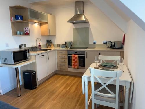a kitchen with a table and a stove and a microwave at Apartment - Centre of Swanage Stunning Sea views in Swanage