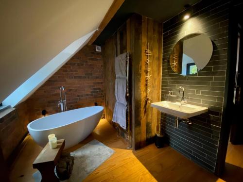 a bathroom with a white tub and a sink at Stunning 3BD Character House near Coleshill in Birmingham