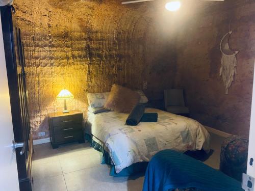 a bedroom with a bed with a laptop on it at Pop’n’nin Dugout Accommodation at Coober Pedy Views in Coober Pedy