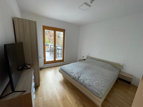 Schlafzimmer mit einem Bett und einem Fenster in der Unterkunft Luxury 3-room large Apartment Maribor Pohorje in Hočko Pohorje