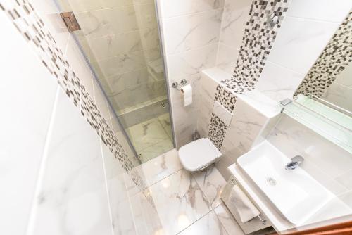La salle de bains est pourvue d'une douche, de toilettes et d'un lavabo. dans l'établissement Apartments Brezovka, à Novalja