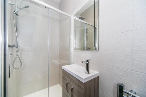 a white bathroom with a sink and a shower at 14 Helena House Lux Apartment in Reading