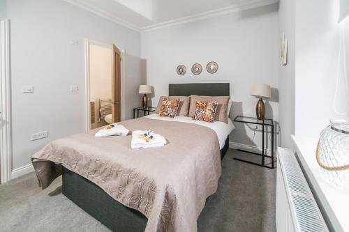 a bedroom with a large bed with towels on it at 14 Helena House Lux Apartment in Reading