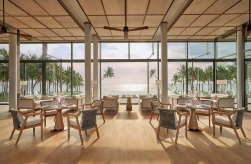 a restaurant with tables and chairs and a view of the ocean at Regent Phu Quoc in Phu Quoc