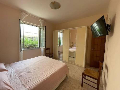 Schlafzimmer mit einem Bett, einem TV und einem Spiegel in der Unterkunft Appartamento 10 m dal mare Casa da zia Lena Maiori in Maiori