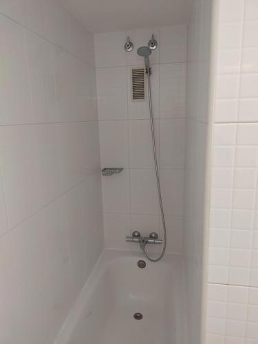 eine Dusche im weißen Badezimmer mit Duschkopf in der Unterkunft Luxury Apartment Accommodation, next to beach & train station Calella in Calella