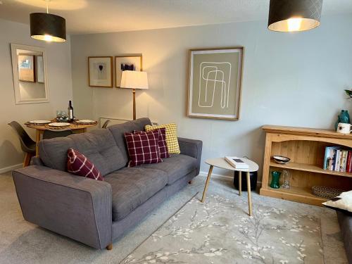 a living room with a gray couch and a table at Chic 2BR Haven - Contemporary Flat in Hoddesdon in Hoddesdon