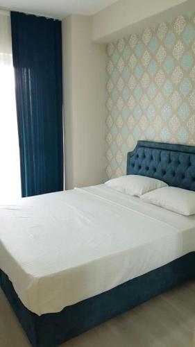 um quarto com uma cama grande e uma cabeceira azul em Express24 1+1Fun in the middle of the city 81 em Istambul