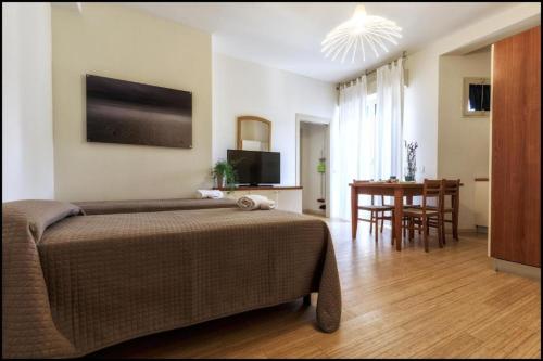 a bedroom with a bed and a dining room at Residence Rivaverde in Marina di Ravenna