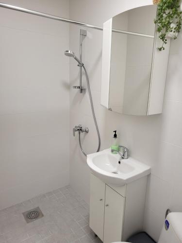 a white bathroom with a sink and a mirror at Old Town Apartment nr 2 in Valga
