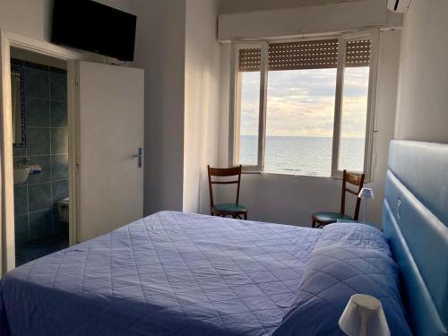 - une chambre avec un lit et une vue sur l'océan dans l'établissement Hotel Sirenetta, à Anzio