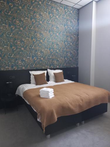 a bedroom with a large bed with a damask wall at Boutique Hotel De Oude Veste in Hellevoetsluis