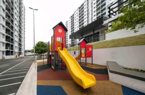 a playground with a yellow slide in a city at Pangsapuri Desaru Utama Homestay in Bandar Penawar