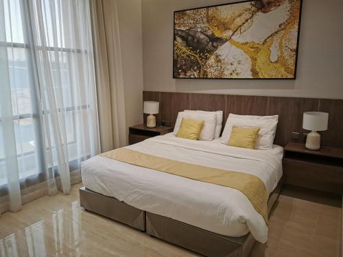 a bedroom with a large bed with yellow pillows at شقة راقية بثلاث غرف نوم ودخول ذاتي in Riyadh
