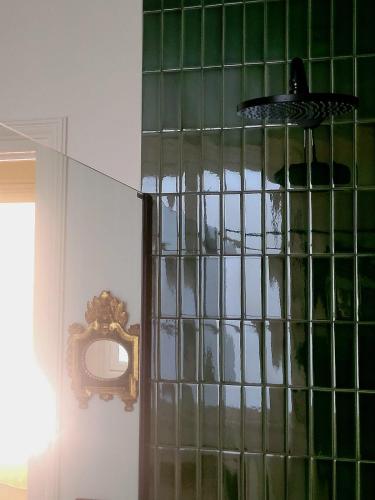 - une douche avec du carrelage vert sur un mur avec un miroir dans l'établissement La Chambre du 21, à Trouville-sur-Mer