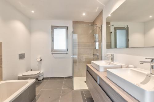 a white bathroom with two sinks and a toilet at Jardines - Acoran 3-2 PENTHOUSE NATURAL RESERVE VIEW & JACUZZI in Palm-mar