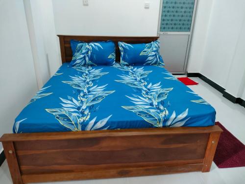 a bed with blue sheets and blue pillows at Victory's Gardens in Mannar