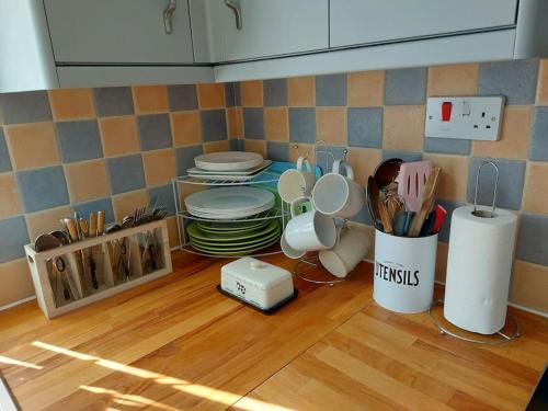 a kitchen with plates and utensils on a wooden floor at Comfortable 2 bedroom house in historic Exeter in Exeter