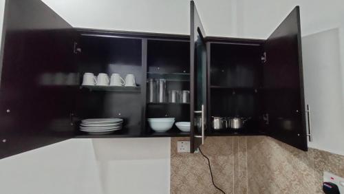 a black cabinet with plates and dishes in it at Victory's Gardens in Mannar