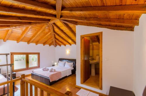 1 dormitorio con cama y techo de madera en Villa Louisa en Kanapitsa