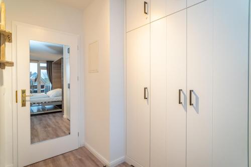 a room with white cabinets and a mirror at Bismarck-Koje in Westerland