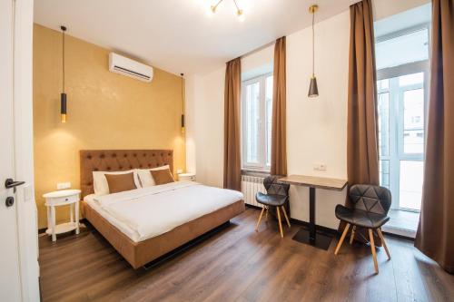 Schlafzimmer mit einem Bett und einem Schreibtisch mit Stühlen in der Unterkunft Central Apartments Palats Sportu Area in Kiew