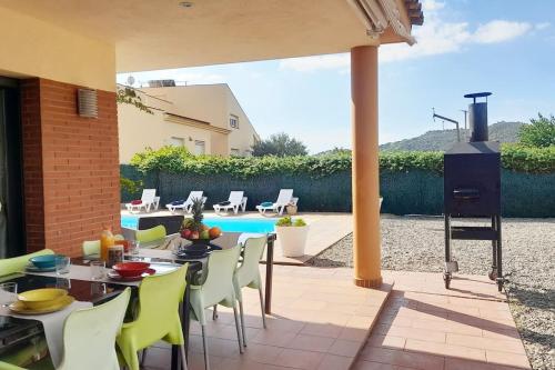 a patio with a table and chairs and a pool at Villa Mediterránea con Cinco Dormitorios y Piscina in Calonge